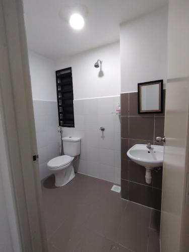 a bathroom with a toilet and a sink at QA Homestay in Tawau