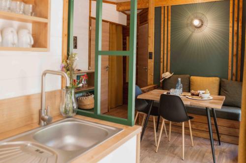 une cuisine avec un évier et une table avec des chaises dans l'établissement Slow Village Saint-Cybranet - Périgord, à Saint-Cybranet