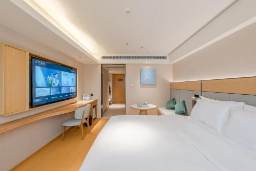 a hotel room with a large bed and a flat screen tv at JI Hotel Guangzhou Ximenkou in Guangzhou