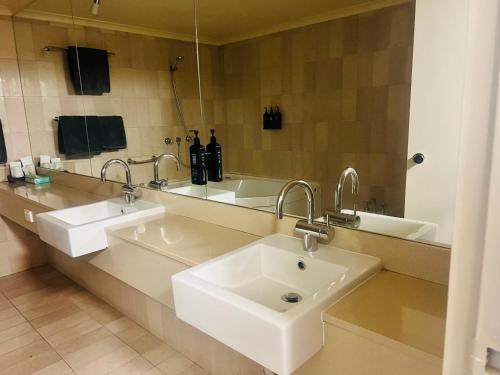 ワガワガにあるPavilion Hotel Wagga Waggaの洗面台が2つと大きな鏡があるバスルーム