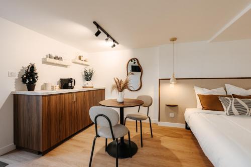 a bedroom with a bed and a table and chairs at L'Alma- Accès Privée-Proche Aéroport-Parking-Wifi in Achenheim