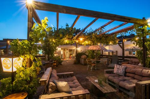 a patio at night with couches and tables at B&B Katoo in Linne