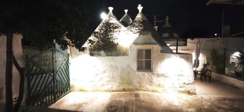 a white building with lights on it at night at Il trullo della nonna in Martina Franca