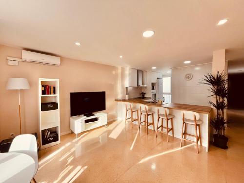 a living room with a kitchen with a bar with stools at Piso en Centro-Fortaleza Santa Pola in Santa Pola