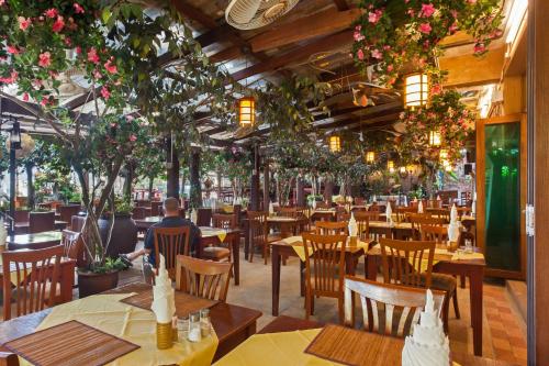 a restaurant with tables and chairs and flowers at Tropica Bungalow Beach Hotel in Patong Beach