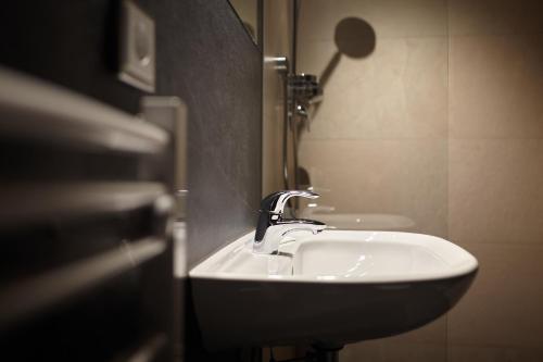 a white sink in a bathroom next to a wall at Piltriquitron Lodging in Sankt Anton am Arlberg