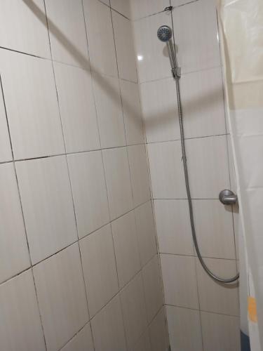 eine Dusche mit Schlauch in einem weiß gefliesten Badezimmer in der Unterkunft Optimal 1 in Kiew