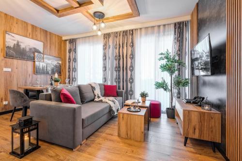 a living room with a couch and a table at Apartamenty SKI Apartments, Odkryj-Bialke in Białka Tatrzańska