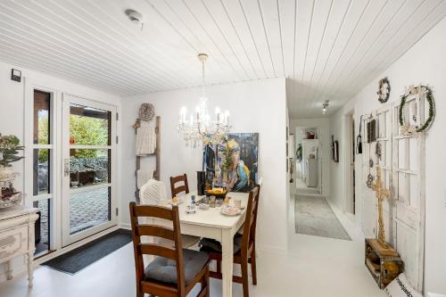 a dining room with a table and chairs and a chandelier at Tina Risager bed & breakfast in Sindal