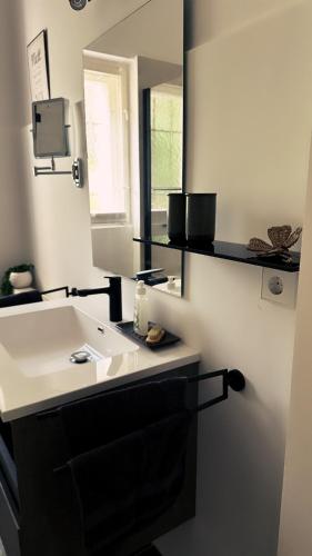a bathroom with a sink and a mirror at Ferienwohnung Seelenruh in Falkensee