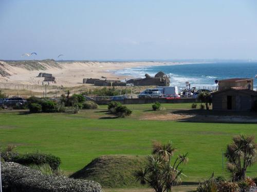 uma vista para uma praia com um campo de relva em Studio Residence Le Signal em Capbreton