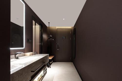 Atour Hotel Shanghai North Bund Riverside International Plaza في شانغهاي: حمام مع حوض ومرآة