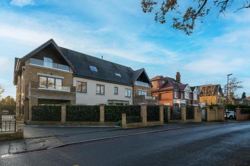a white house with a black roof on a street at The Isleworth Garden Retreat 3BR 2BA with Gated Parking in Isleworth