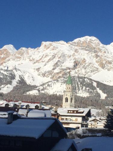 a snow covered mountain with a town and a church at Meuble Villa Neve in Cortina dʼAmpezzo
