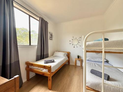 a bedroom with two bunk beds and a window at Beachside Cabin No 2 at Island Beach in Island Beach