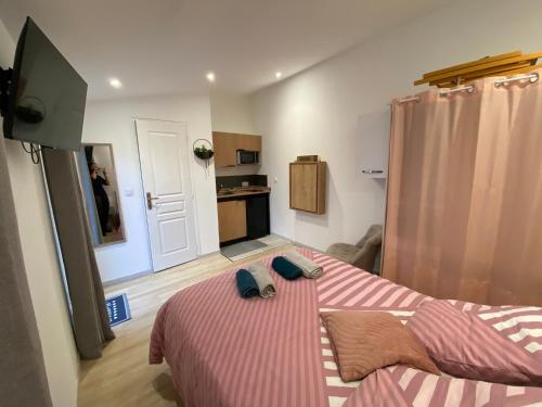 ein Schlafzimmer mit einem Bett, auf dem zwei Handtücher liegen in der Unterkunft Maisonnette cosy au calme terrasse local vélo in Rochefort