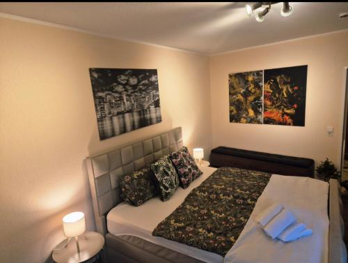 Hafenperle Ferienwohnung am Alten Stadthafen in Oldenburg - Zentrale City Lage في أولدنبورغ: غرفة نوم بسرير وصورتين على الحائط