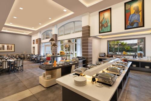 Un restaurante con mesas y sillas y un bar. en Sangam Hotel, Thanjavur, en Thanjāvūr