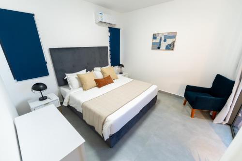 a hotel room with a bed and a chair at Arama Villa by Swarga Mauritius in Cap Malheureux