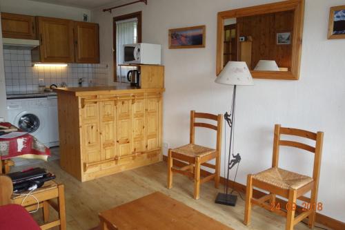 a kitchen with two chairs and a table and a lamp at Appartement Les Balcons du Savoy in Chamonix-Mont-Blanc