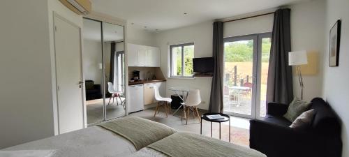 a bedroom with a bed and a kitchen with a table at Domaine équestre de la Chênaie in Saumur