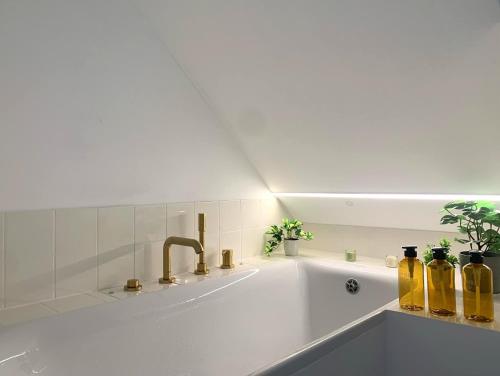 a white bathroom with a sink with bottles on it at kremsoase in Krems an der Donau