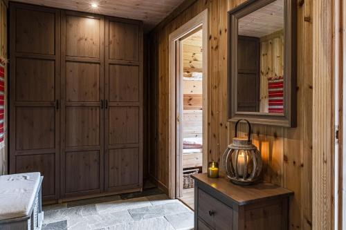 een kamer met houten kasten en een lantaarn op een tafel bij Charming cabin in Hemsedal Golf Alpin - ideal for families, fishing & skiing in Granheim