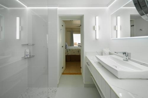 a white bathroom with a sink and a mirror at Sea View - Glitter Bay in Saint James