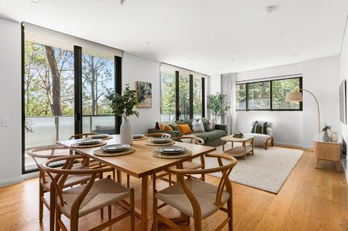 ein Wohnzimmer mit einem Holztisch und Stühlen in der Unterkunft Upper North Shore Haven - A Tranquil Treetop Escape in Warrawee