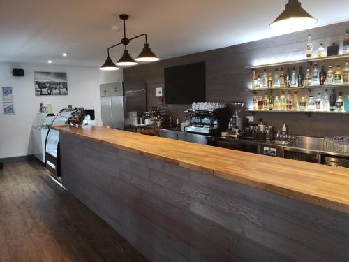 een bar met een houten bar in een restaurant bij Lochmaddy Hotel in Lochmaddy