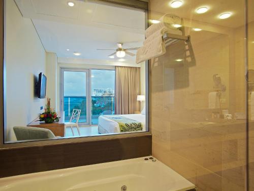 a bathroom with a tub and a bedroom with a window at Las Americas Torre Del Mar in Cartagena de Indias