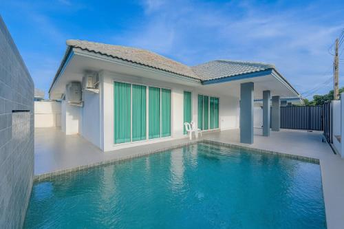a house with a swimming pool in front of it at 芭提雅 私人泳池别墅 中天海滩 别墅预定 家庭私密度假别墅 4卧室5卫2厅 in Jomtien Beach