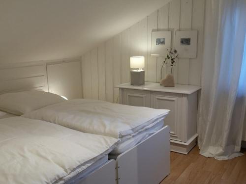 Fewo Am Wald في Balve: غرفة نوم بها سريرين وطاولة مع مصباح