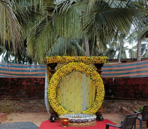 Baada Beach VT stay في Tadri: إكليل أصفر كبير على منصة مزينة بأشجار النخيل