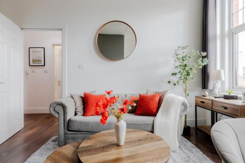 a living room with a couch and a table with red pillows at The Regency | Seafront Lux Apartments! in Southend-on-Sea