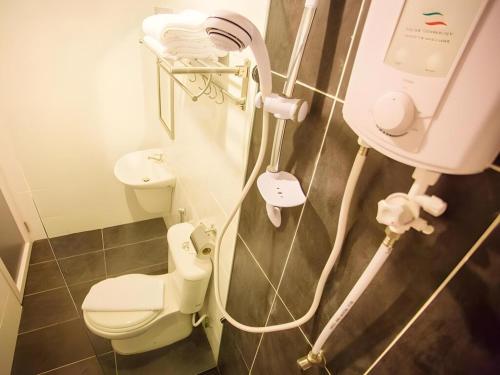 a bathroom with a white toilet and a sink at Victory City Hotel Crystal Bay in Iskandar Puteri