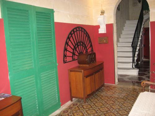 a room with green doors and a table and stairs at The 1930's Maltese Residence in St Paul's Bay
