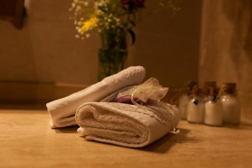 a towel sitting on a table with a vase of flowers at Kale Konak Cappadocia in Uchisar