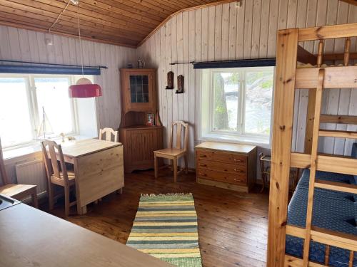 a bedroom with a bunk bed and a desk and a table at Dog-friendly cottage with boat & private jetty at Tjörn SE09170 in Krommeröd