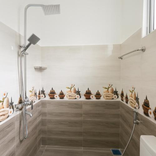 a bathroom with a shower and lots of vases at Skyport Villa Katunayaka in Katunayaka