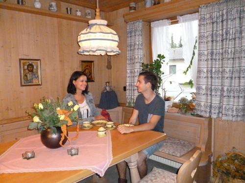 Ein Mann und eine Frau sitzen an einem Tisch in der Unterkunft Ferienwohnungen Fontana in Bad Gögging