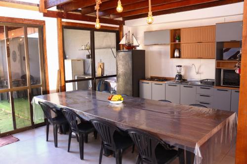 a kitchen with a large wooden table and chairs at Sobrado São Chico, Ubatuba SFS in São Francisco do Sul