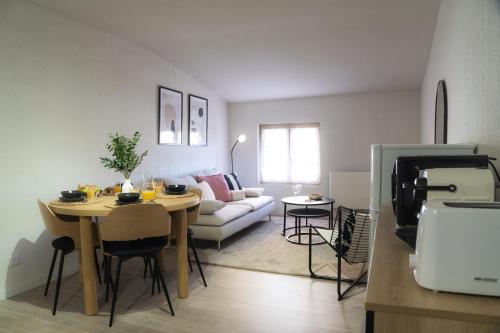una sala de estar con una mesa y un sofá en Appartement moderne, 2 chambre, Hyères centre, en Hyères
