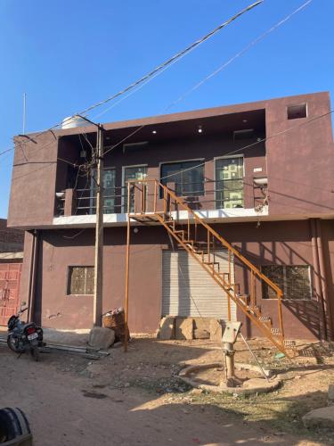 a house with a staircase in front of it at Hari Har guest house in Chhatarpur