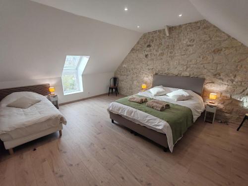 Ένα ή περισσότερα κρεβάτια σε δωμάτιο στο Longère de charme rénovée - dépaysement et verdure