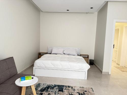 ein weißes Schlafzimmer mit einem Bett und einer Couch in der Unterkunft comfortable hotel Jeddah in Dschidda