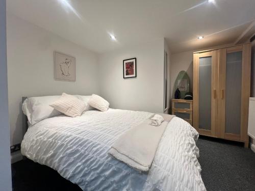 a bedroom with a bed with a white comforter at The Bluebird B&B I in Headingley