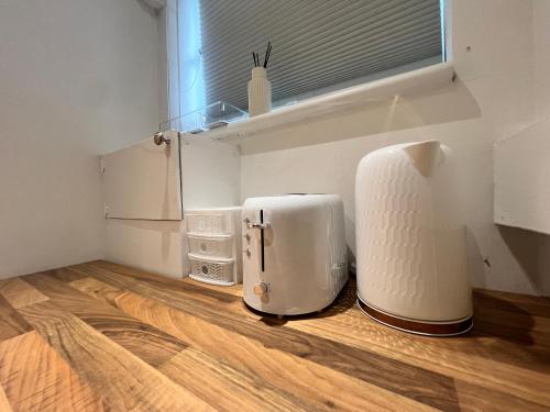 a white appliance sitting on top of a wooden floor at The Bluebird Rooms I in Headingley