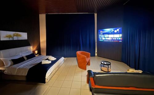 Maison Mimosa avec garage privé في دينانت: غرفة نوم بسرير وكرسي وتلفزيون