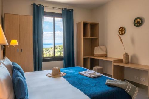a bedroom with a bed with a blue blanket and a window at Les appartements de l'Helios - Ile des Embiez in Six-Fours-les-Plages